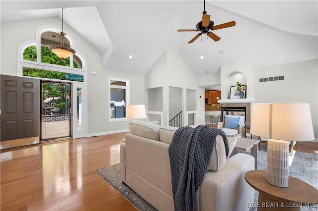 1129 Beacon Pointe Cir, Lake Ozark, MO 65049 - living area with high vaulted ceiling, a ceiling fan, wood finished floors, and a multi sided fireplace