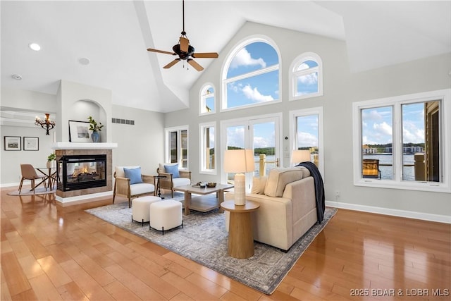 1129 Beacon Pointe Cir, Lake Ozark, MO 65049 - living room featuring high vaulted ceiling, hardwood / wood-style flooring, a tile fireplace, and a ceiling fan