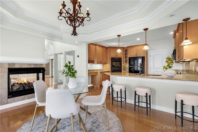 1129 Beacon Pointe Cir, Lake Ozark, MO 65049 - dining room with a tray ceiling, wood finished floors, crown molding, a chandelier, and recessed lighting