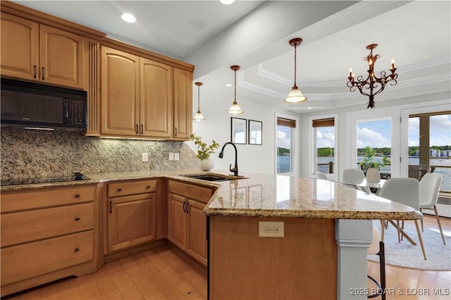 1129 Beacon Pointe Cir, Lake Ozark, MO 65049 - kitchen with black appliances, backsplash, light stone countertops, a peninsula, and light wood-style floors