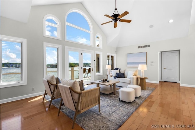1129 Beacon Pointe Cir, Lake Ozark, MO 65049 - living area with high vaulted ceiling, light wood-style floors, a ceiling fan, and plenty of natural light