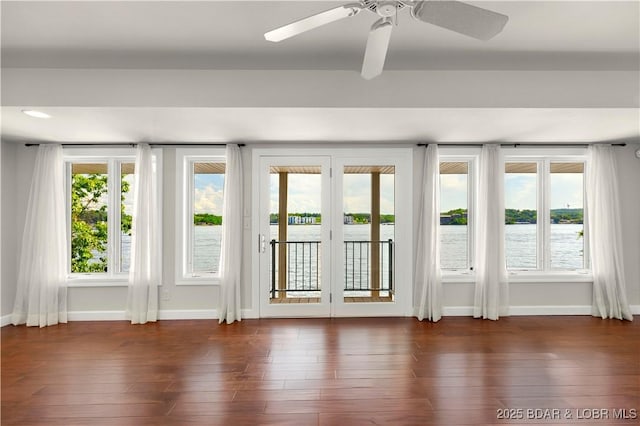 1129 Beacon Pointe Cir, Lake Ozark, MO 65049 - empty room featuring dark wood finished floors, ceiling fan, and a water view