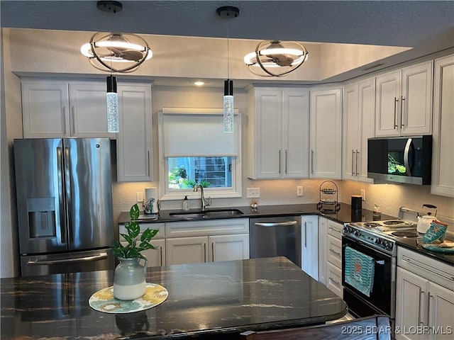 757 Malibu Rd Unit 101B, Osage Beach, MO 65065 - kitchen featuring stainless steel appliances, decorative light fixtures, dark stone countertops, and white cabinets