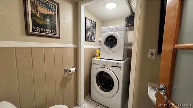 2096 Birchwood Ln, Osage Beach, MO 65065 - laundry room with stacked washing machine and dryer, light tile patterned floors, and a wainscoted wall