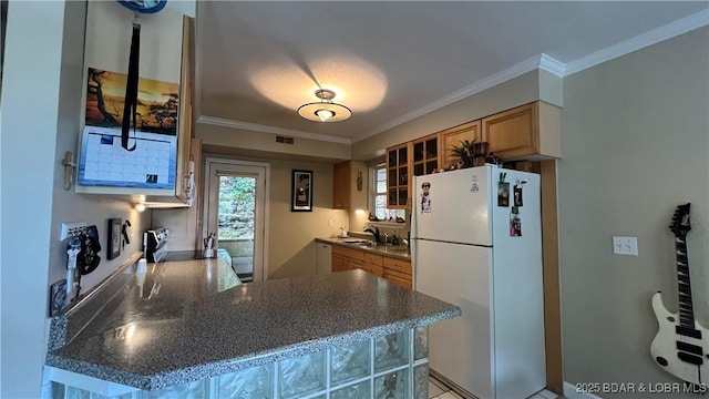 2096 Birchwood Ln, Osage Beach, MO 65065 - kitchen with freestanding refrigerator, a peninsula, dark countertops, and ornamental molding