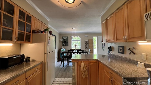 2096 Birchwood Ln, Osage Beach, MO 65065 - kitchen featuring crown molding, glass insert cabinets, brown cabinetry, a peninsula, and freestanding refrigerator