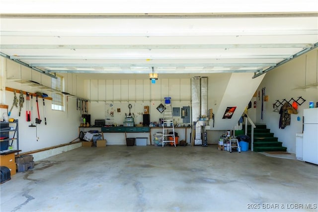 2174 State Road V, Linn Creek, MO 65052 - garage featuring freestanding refrigerator, a workshop area, and electric panel