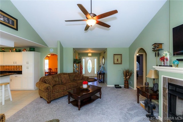 2174 State Road V, Linn Creek, MO 65052 - living area featuring arched walkways, lofted ceiling, a ceiling fan, a fireplace, and light carpet