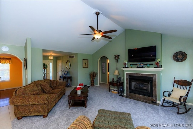 2174 State Road V, Linn Creek, MO 65052 - carpeted living room with arched walkways, a ceiling fan, a tile fireplace, and vaulted ceiling