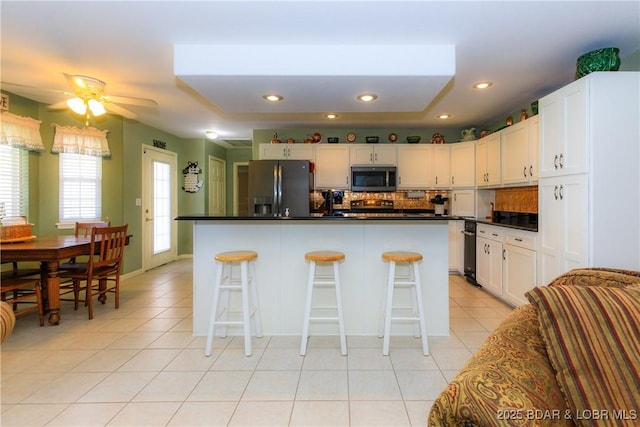2174 State Road V, Linn Creek, MO 65052 - kitchen featuring appliances with stainless steel finishes, tasteful backsplash, dark countertops, light tile patterned floors, and recessed lighting