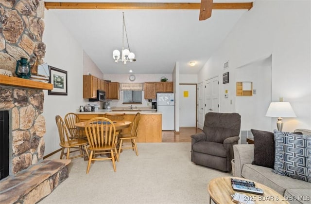 611 Lazy Days Rd Unit B11, Osage Beach, MO 65065 - living area featuring a stone fireplace, a chandelier, high vaulted ceiling, beam ceiling, and light carpet