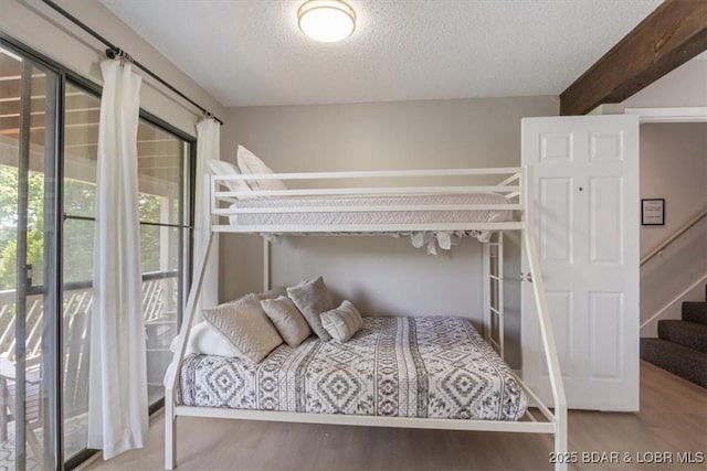 392 Hopetown Dr, Osage Beach, MO 65065 - bedroom with a textured ceiling, wood finished floors, and beamed ceiling