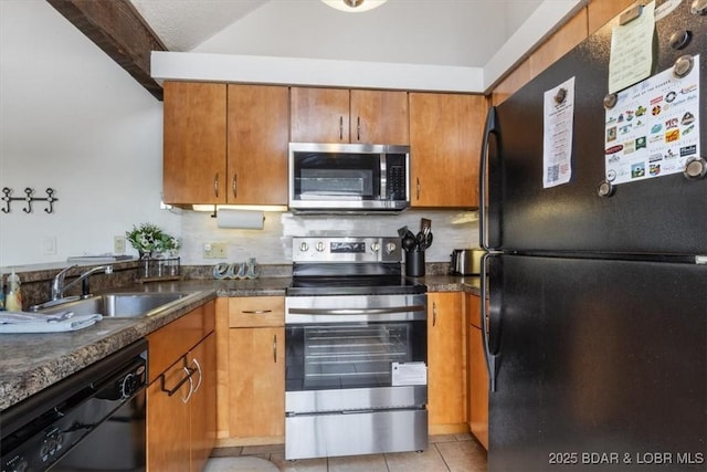 392 Hopetown Dr, Osage Beach, MO 65065 - kitchen with black appliances, brown cabinets, dark countertops, vaulted ceiling, and light tile patterned floors
