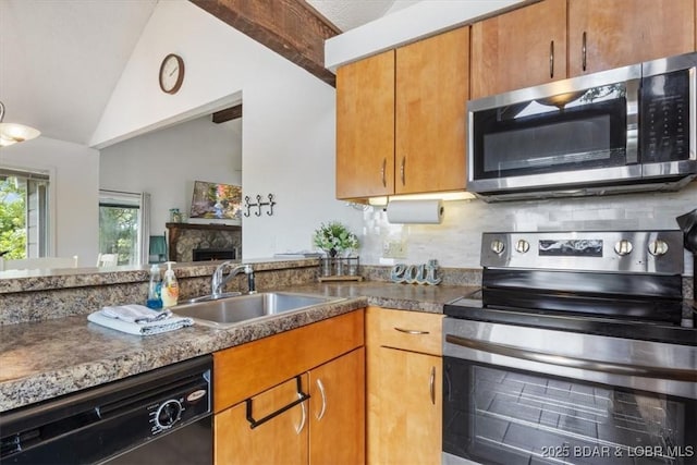 392 Hopetown Dr, Osage Beach, MO 65065 - kitchen featuring stainless steel appliances, vaulted ceiling, a stone fireplace, tasteful backsplash, and brown cabinetry