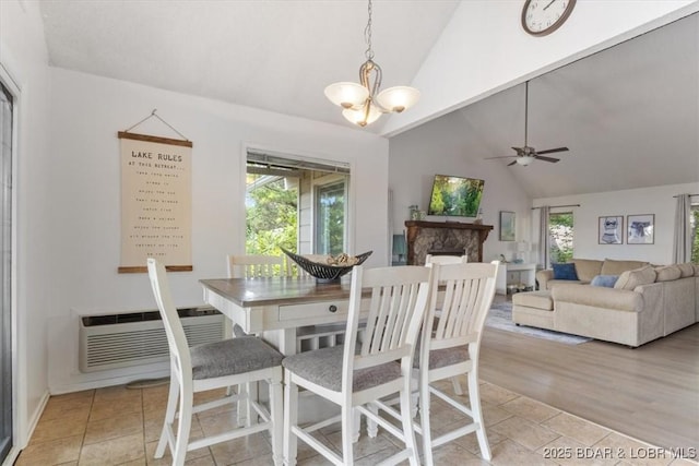 392 Hopetown Dr, Osage Beach, MO 65065 - dining room featuring plenty of natural light, a fireplace, high vaulted ceiling, a ceiling fan, and a chandelier