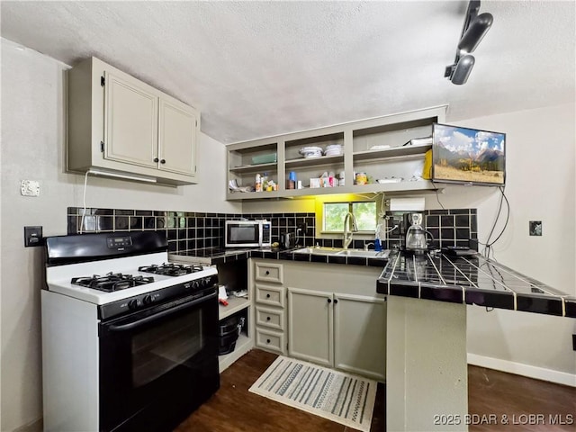 30424 Violet Rd, Gravois Mills, MO 65037 - kitchen with gas range oven, tile counters, stainless steel microwave, open shelves, and tasteful backsplash