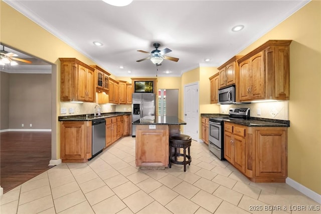 22 Hand Ln, Eldon, MO 65026 - kitchen with stainless steel appliances, ceiling fan, a breakfast bar, recessed lighting, and brown cabinets