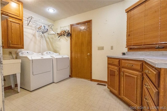 170 Twin Oaks Dr, Lake Ozark, MO 65049 - laundry room with washer and clothes dryer, cabinet space, and a textured ceiling