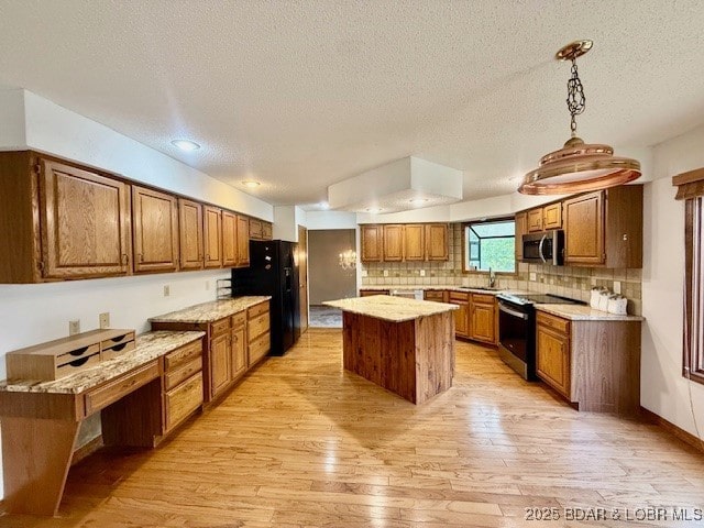 170 Twin Oaks Dr, Lake Ozark, MO 65049 - kitchen with stainless steel microwave, electric stove, brown cabinets, freestanding refrigerator, and light wood-style flooring