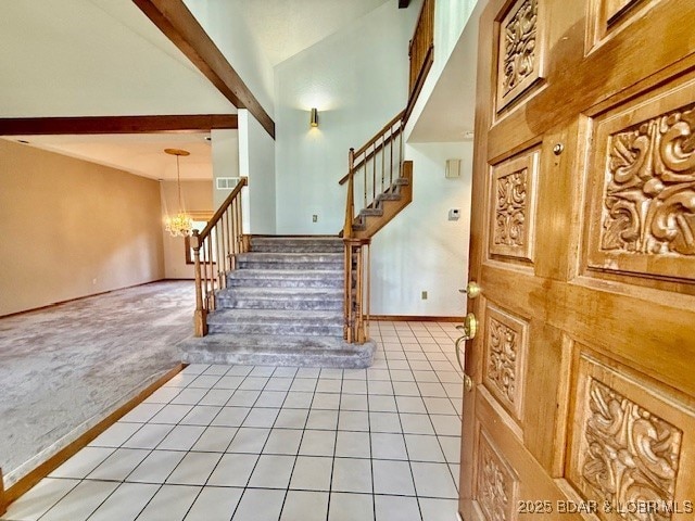 170 Twin Oaks Dr, Lake Ozark, MO 65049 - entryway with stairs, light tile patterned floors, a towering ceiling, light colored carpet, and a chandelier