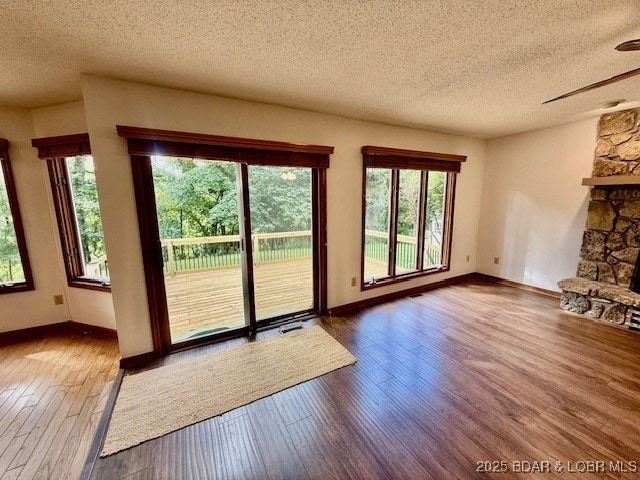 170 Twin Oaks Dr, Lake Ozark, MO 65049 - doorway to outside featuring a textured ceiling, hardwood / wood-style flooring, a ceiling fan, and a fireplace