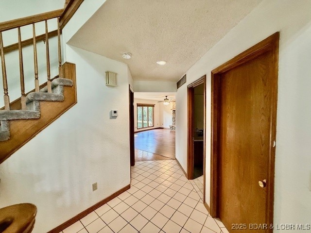 170 Twin Oaks Dr, Lake Ozark, MO 65049 - hall with a textured ceiling, light tile patterned flooring, and stairs