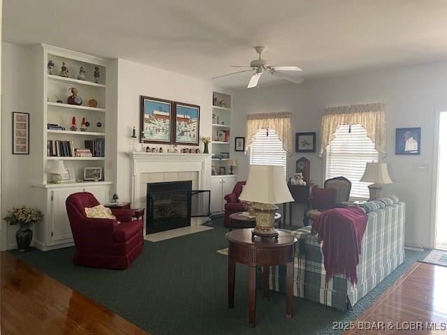 130 Guinevere Ct, Camdenton, MO 65020 - living area featuring a fireplace, ceiling fan, built in features, and wood finished floors