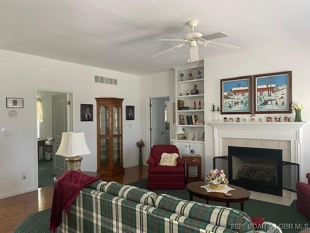 130 Guinevere Ct, Camdenton, MO 65020 - living room featuring a ceiling fan, wood finished floors, and a tile fireplace