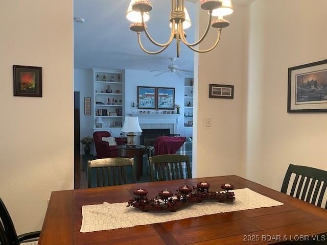 130 Guinevere Ct, Camdenton, MO 65020 - dining area featuring a chandelier, built in shelves, ceiling fan, and a fireplace