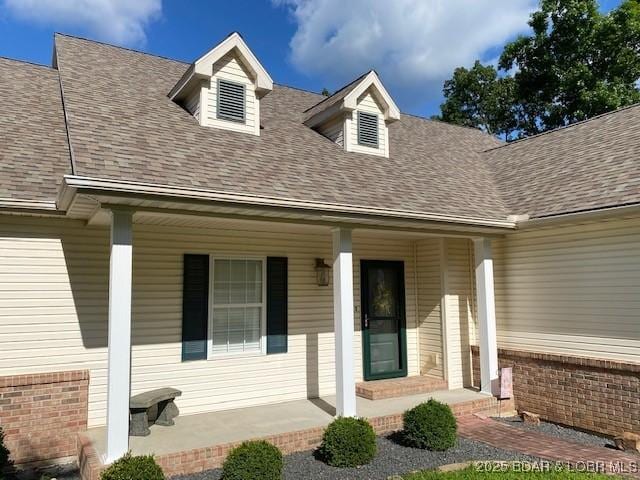 130 Guinevere Ct, Camdenton, MO 65020 - entrance to property with covered porch, roof with shingles, and brick siding