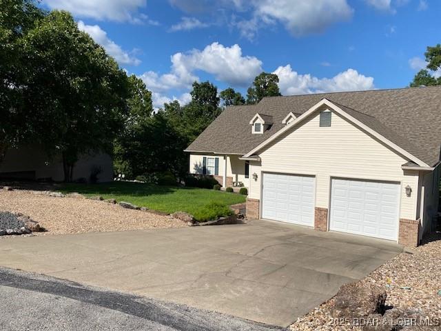 130 Guinevere Ct, Camdenton, MO 65020 - view of front of property with brick siding, a garage, driveway, and a front yard