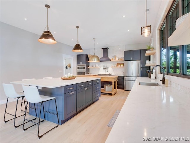 92 Arrowhead Beach Rd, Lake Ozark, MO 65049 - kitchen featuring open shelves, appliances with stainless steel finishes, backsplash, a kitchen island, and wall chimney range hood