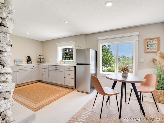 92 Arrowhead Beach Rd, Lake Ozark, MO 65049 - kitchen with freestanding refrigerator, light countertops, a wainscoted wall, and recessed lighting