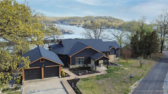 92 Arrowhead Beach Rd, Lake Ozark, MO 65049 - view of front facade featuring driveway, stone siding, an attached garage, and a water view