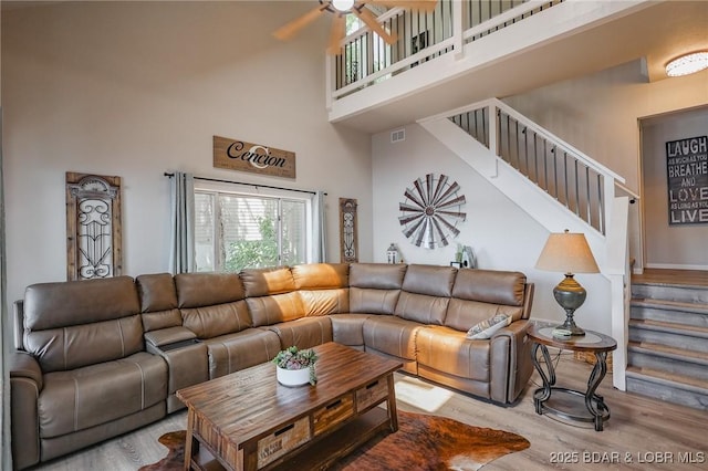 35 Port Bagnell W, Eldon, MO 65026 - living area featuring a towering ceiling, wood finished floors, stairway, and ceiling fan