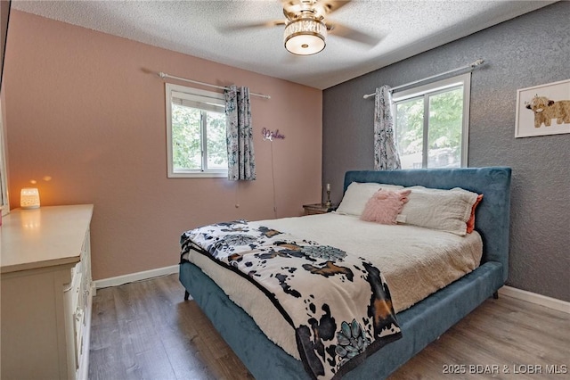35 Port Bagnell W, Eldon, MO 65026 - bedroom featuring multiple windows, wood finished floors, a textured ceiling, and ceiling fan
