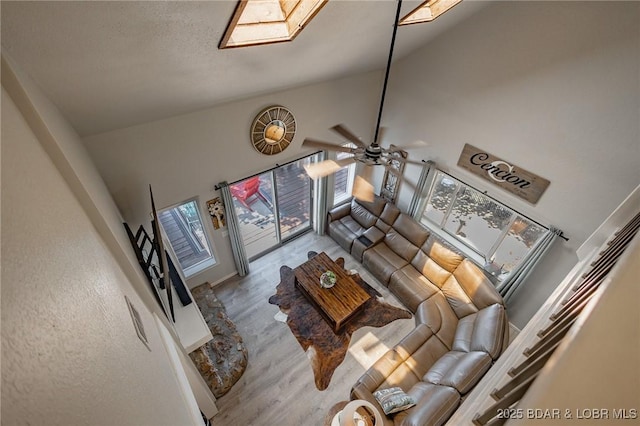 35 Port Bagnell W, Eldon, MO 65026 - living area with high vaulted ceiling, wood finished floors, a skylight, and a ceiling fan