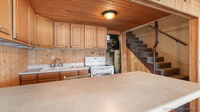 27527 Clyne Dr, Barnett, MO 65011 - kitchen with white range with electric cooktop, light countertops, wooden walls, and electric water heater