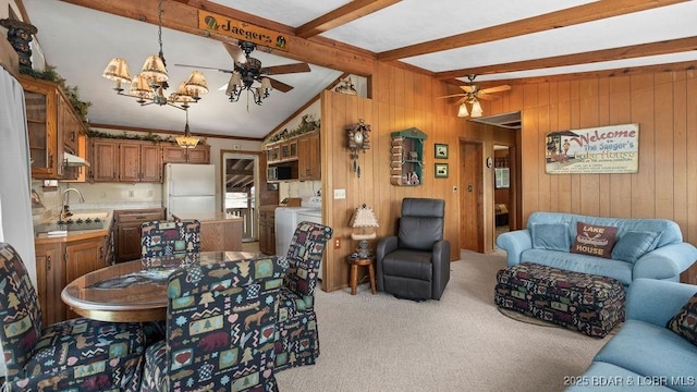 27527 Clyne Dr, Barnett, MO 65011 - dining area featuring a ceiling fan, washer and clothes dryer, light colored carpet, wooden walls, and a chandelier