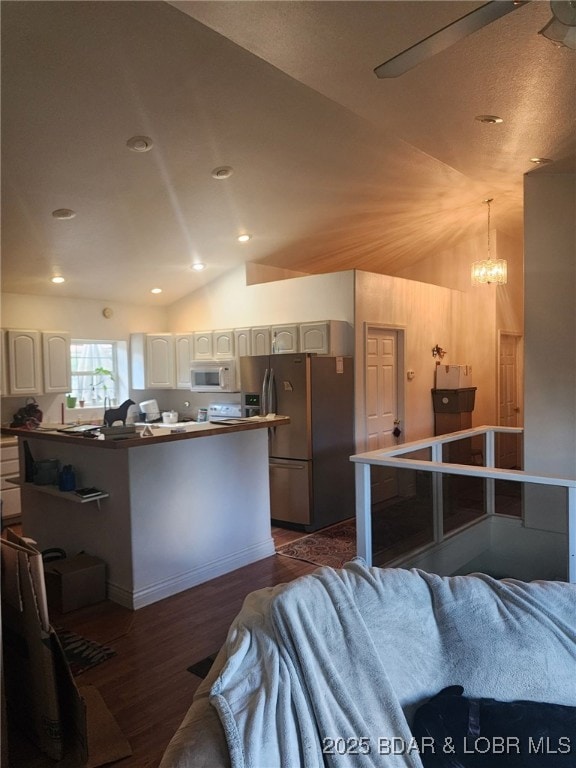 133 Ha Ha Tonka Rd, Camdenton, MO 65020 - kitchen featuring stainless steel fridge with ice dispenser, lofted ceiling, white microwave, dark wood-style flooring, and white cabinetry