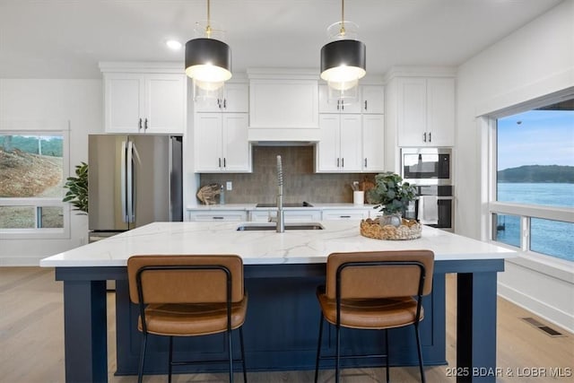 30586 Rapids Holw, Stover, MO 65037 - kitchen with appliances with stainless steel finishes, premium range hood, white cabinetry, tasteful backsplash, and recessed lighting