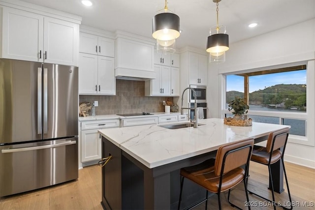30586 Rapids Holw, Stover, MO 65037 - kitchen with stainless steel appliances, white cabinetry, backsplash, a center island with sink, and a kitchen breakfast bar