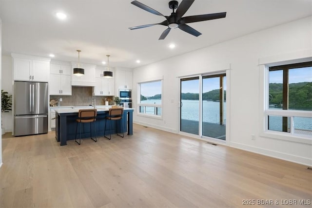 30586 Rapids Holw, Stover, MO 65037 - kitchen featuring appliances with stainless steel finishes, white cabinets, backsplash, light wood-style floors, and recessed lighting