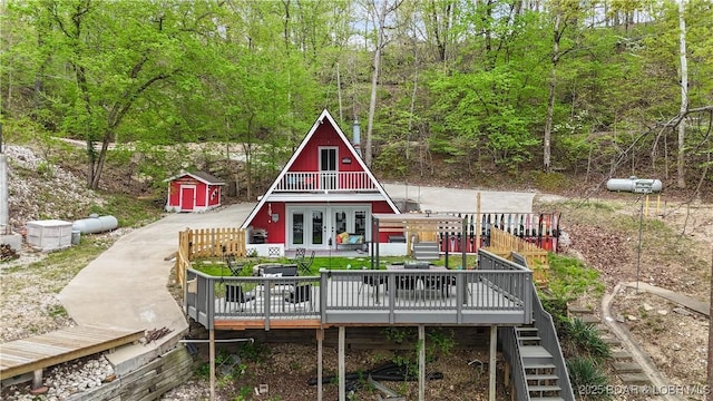 27086 Comanche Cv, Rocky Mount, MO 65072 - back of house with a wooden deck, french doors, stairway, a forest view, and a storage shed