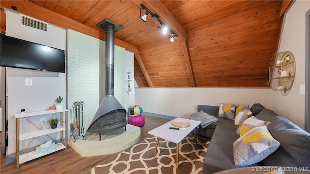 27086 Comanche Cv, Rocky Mount, MO 65072 - living area featuring wooden ceiling, wood finished floors, a wood stove, vaulted ceiling, and track lighting