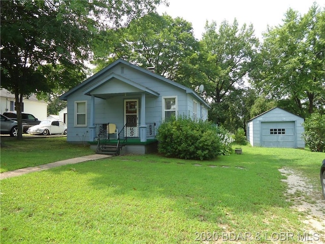 view of front of house with a front lawn, a porch, an outdoor structure, and a garage