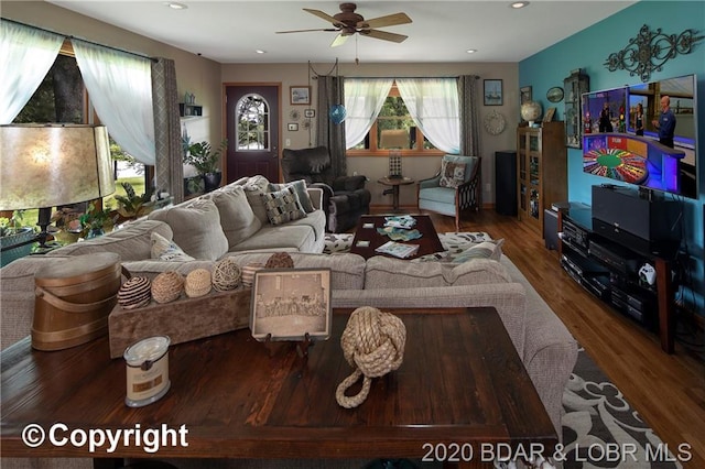 living room with dark hardwood / wood-style flooring and ceiling fan