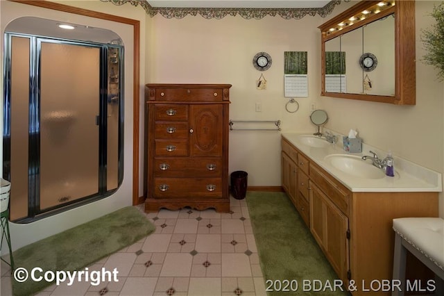 bathroom with double vanity, tile flooring, and a shower with shower door