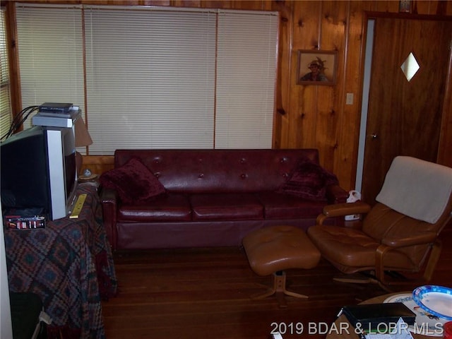 living room featuring wooden walls and dark hardwood / wood-style floors