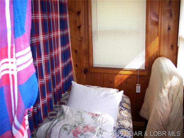 bedroom featuring wooden walls